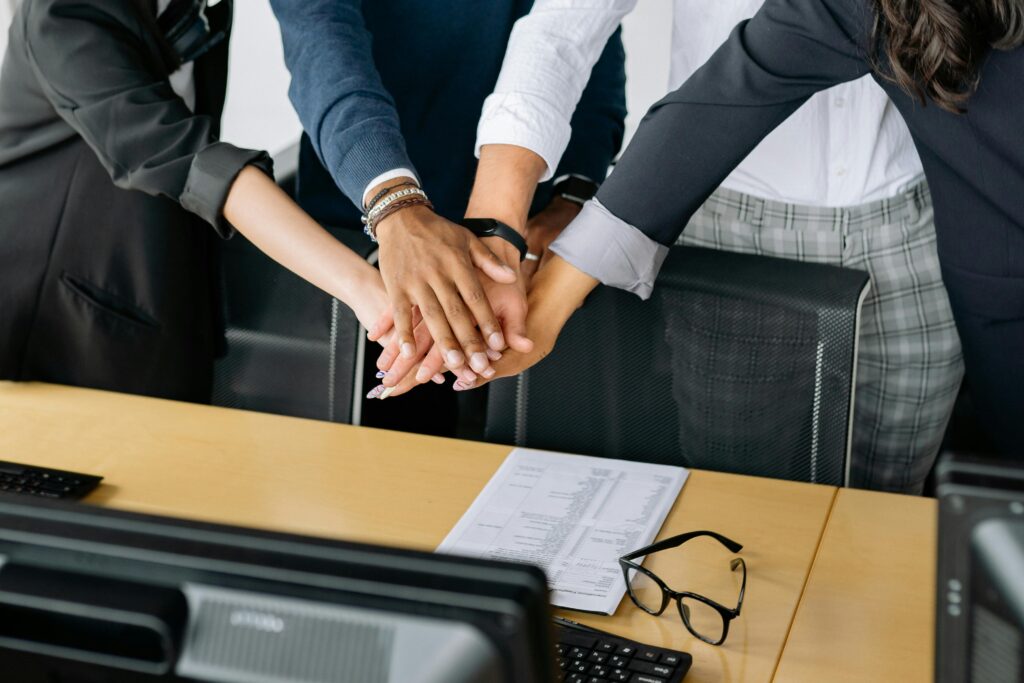 A close-up of a diverse business team stacking hands in unity, showcasing teamwork in an office setting.